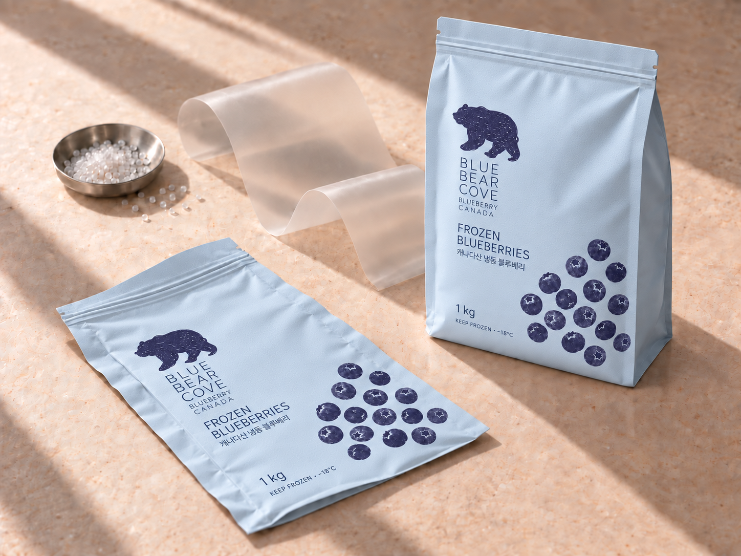 Packaging development with recycled materials in mind: resin pellets, film, a new pouch and an emptied pouch on ivory stone
